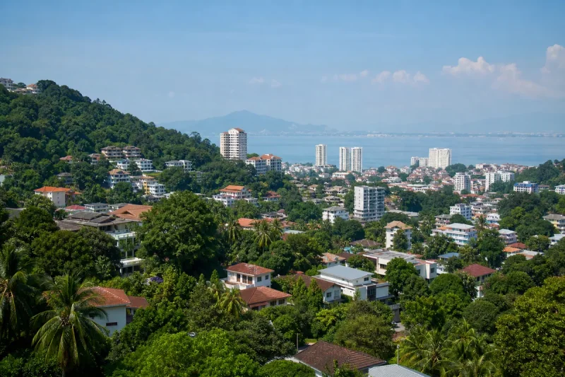 编辑区视觉呈现槟岛的热带山坡和沿海城市环境